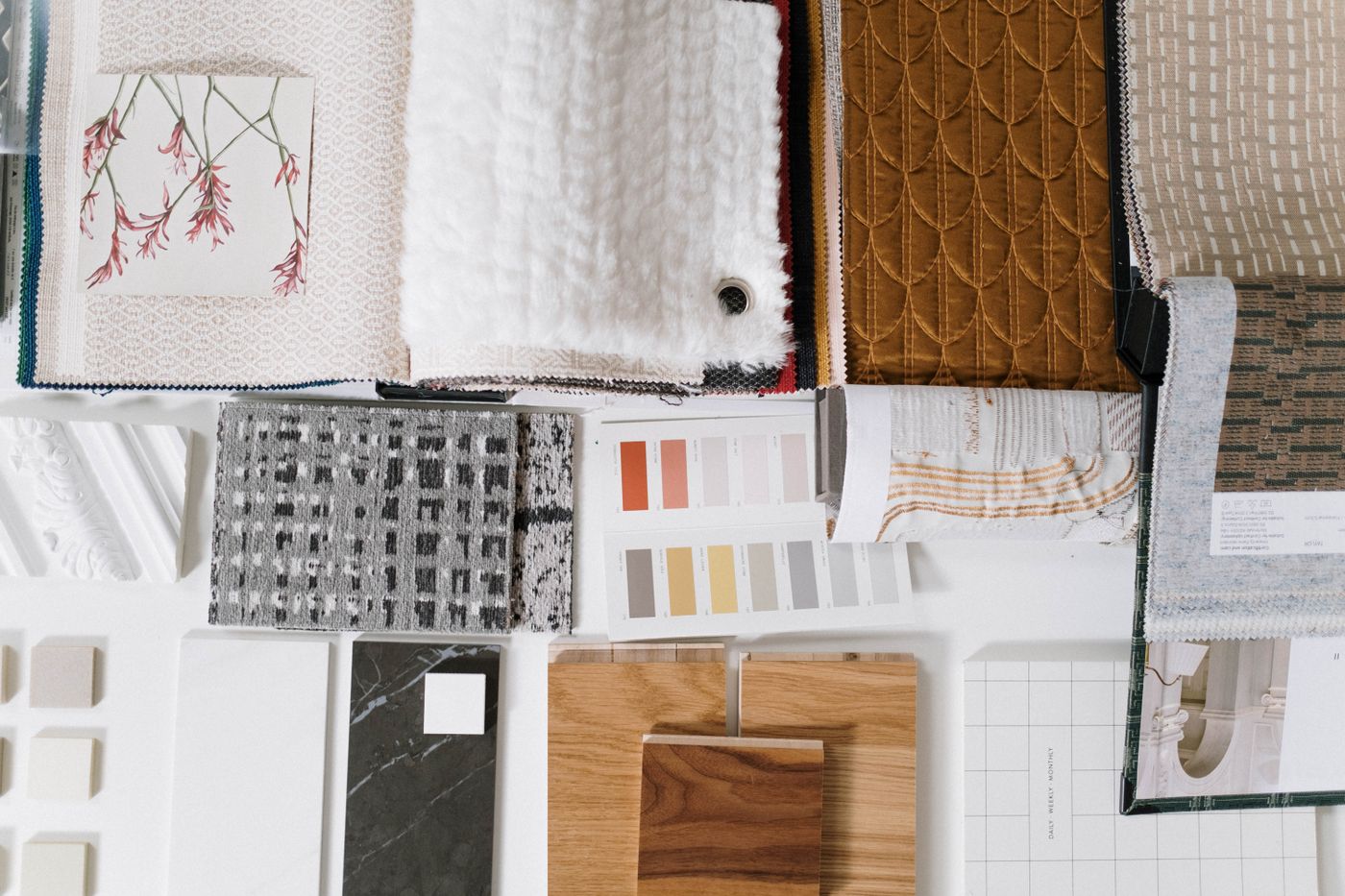 Fabric swatches, paint colors, wood and stone samples arranged on a design mood board